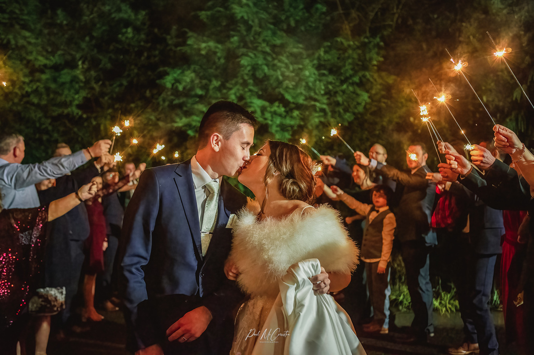 bride and groom kissing under a sparkler tunnel at The Leighinmohr House Hotel